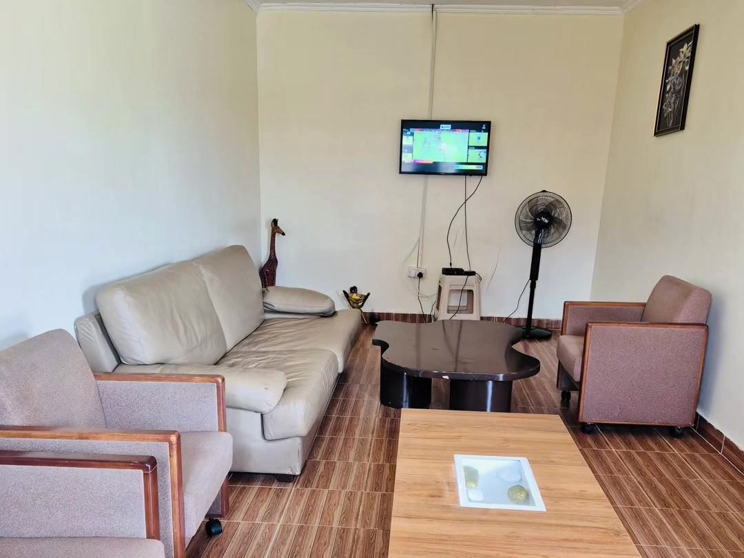 The lounge at Emory Resort with beige sofas, a coffee table and a television