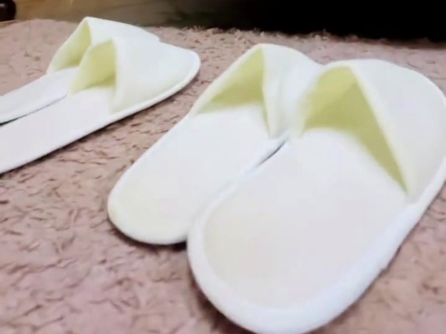 White slippers laid out on the rug in a guest room